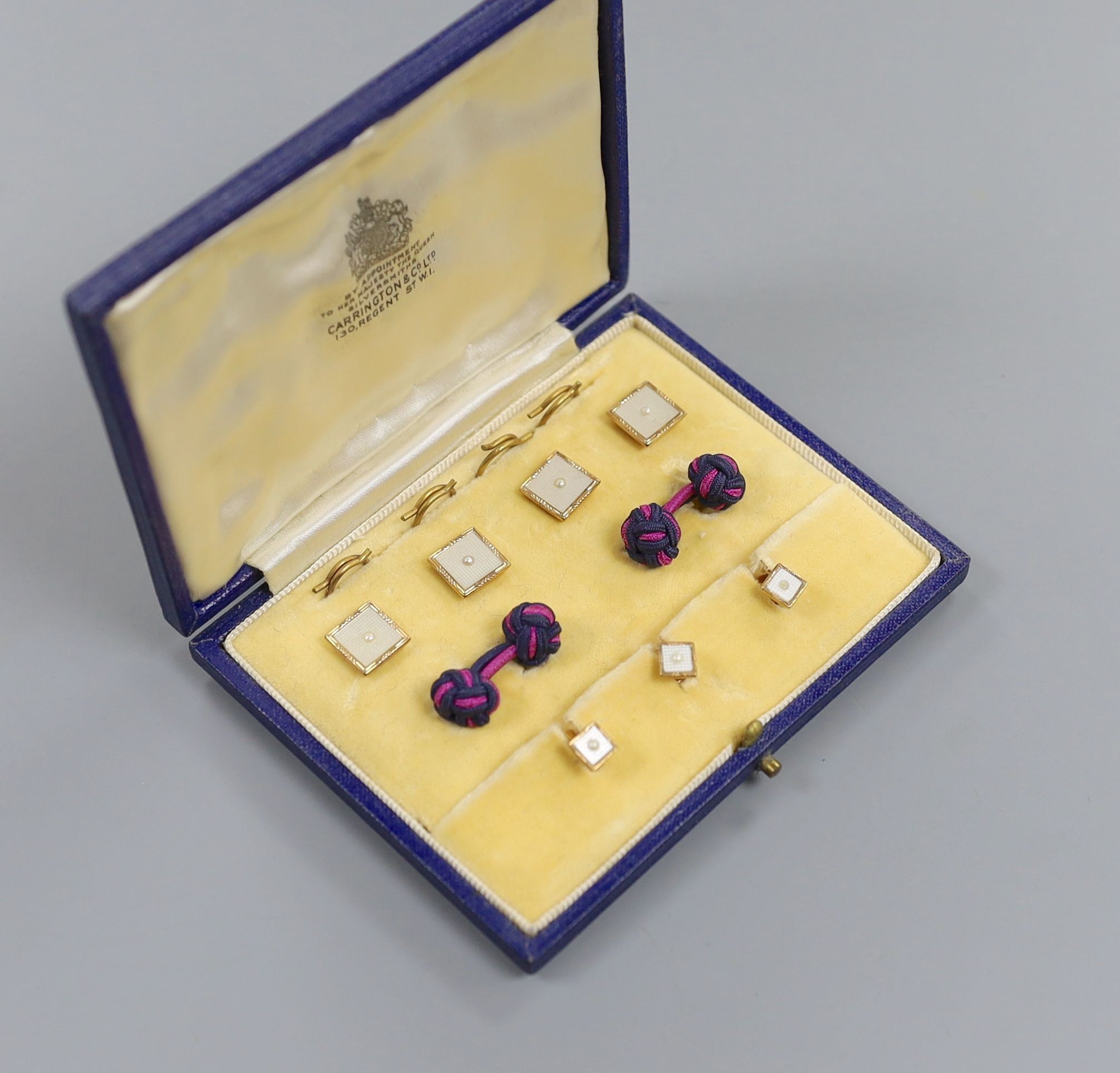 A modern cased seven (ex 9) piece 9ct gold, mother of pearl and seed pearl set dress stud set, gross 7.2 grams.